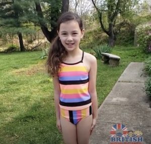 Young girl wearing a rainbow colored swimsuit